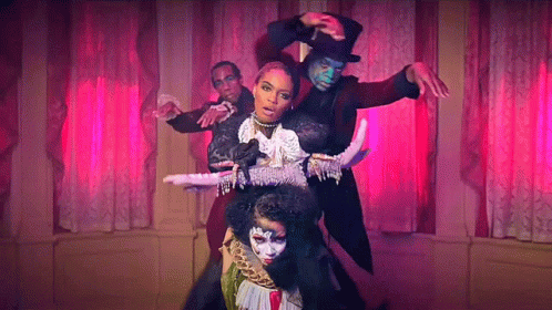 A Group Of People Are Dancing In A Room With Pink Curtains And A Woman In A Top Hat . GIF