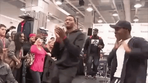 A Group Of People Are Dancing In A Store In Front Of A Crowd Of People . GIF