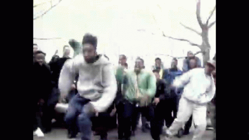 A Group Of People Are Dancing In A Street . GIF