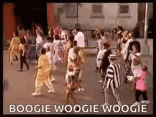 A Group Of People Are Dancing In A Street In Front Of A Building And A Sign That Says Boogie Woogie Woogie . GIF