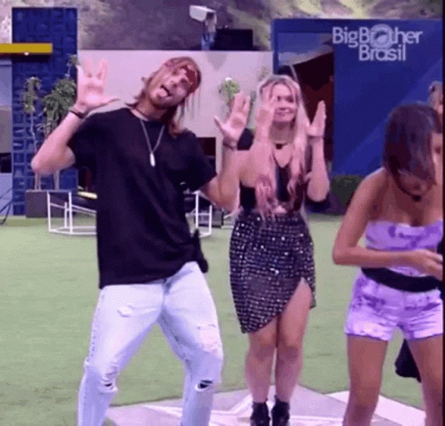 a group of people are dancing in front of a big brother brasil building