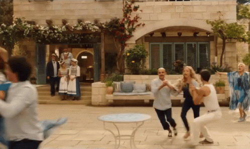 A Group Of People Are Dancing In Front Of A Building In A Movie . GIF