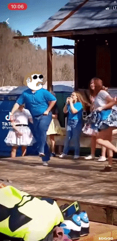 A Group Of People Are Dancing In Front Of A Building With Tik Tok Written On The Screen GIF