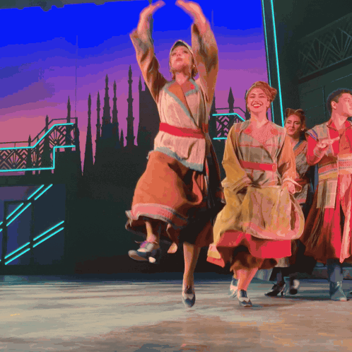 a group of people are dancing in front of a castle