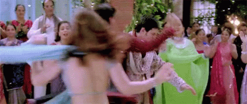 A Group Of People Are Dancing In Front Of A Crowd At A Wedding Reception . GIF