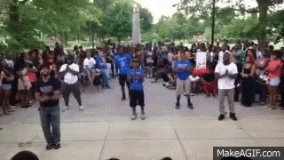 A Group Of People Are Dancing In Front Of A Crowd Of People . GIF