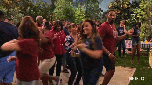 A Group Of People Are Dancing In Front Of A Netflix Ad GIF