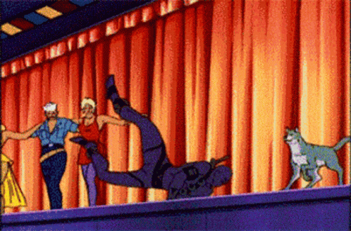 A Group Of People Are Dancing In Front Of A Red Curtain And A Cat GIF