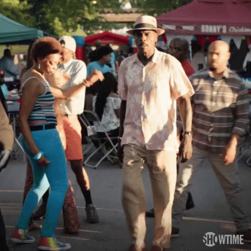 A Group Of People Are Dancing In Front Of A Showtime Sign GIF