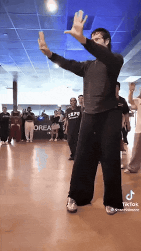 A Group Of People Are Dancing In Front Of A Sign That Says Orea On It GIF