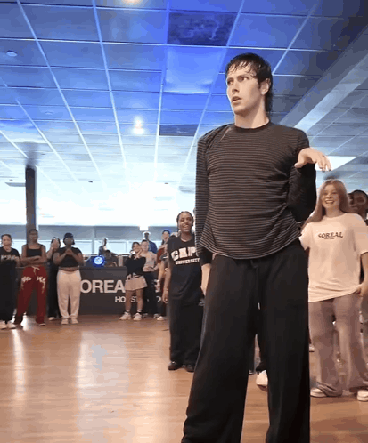 A Group Of People Are Dancing In Front Of A Sign That Says Orea On It GIF
