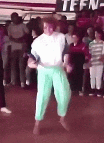 A Group Of People Are Dancing In Front Of A Sign That Says Teen GIF