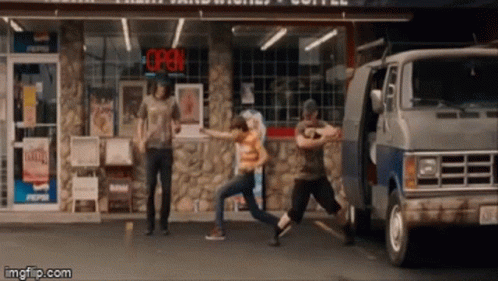 a group of people are dancing in front of a store with an open sign above them