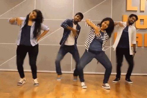 A Group Of People Are Dancing In Front Of A Wall That Has The Letter U On It GIF
