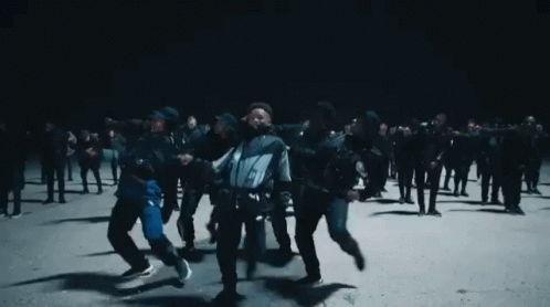 A Group Of People Are Dancing In The Dark GIF