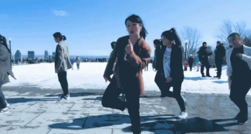 A Group Of People Are Dancing In The Snow And One Of Them Is Wearing A Sweatshirt That Says Guess GIF