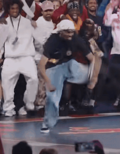 A Group Of People Are Dancing On A Basketball Court And One Of Them Is Wearing A Shirt That Says Nike On It GIF