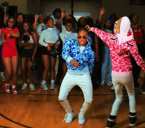 A Group Of People Are Dancing On A Basketball Court GIF