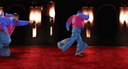 A Group Of People Are Dancing On A Red Carpet In A Dark Room GIF