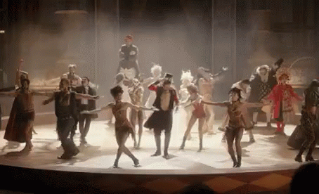 A Group Of People Are Dancing On A Stage In A Circus Show . GIF
