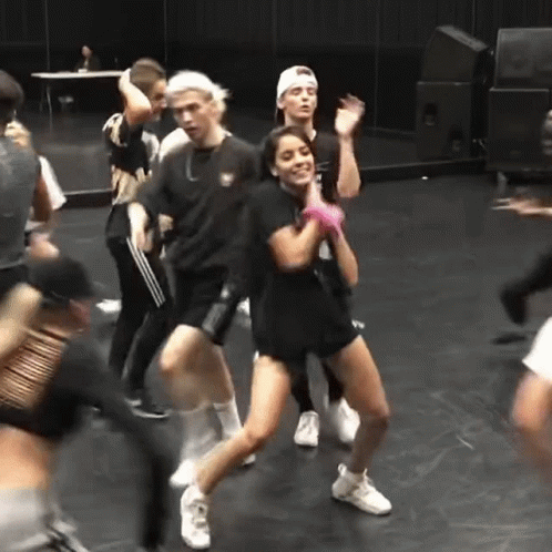 A Group Of People Are Dancing On A Stage In A Room . GIF