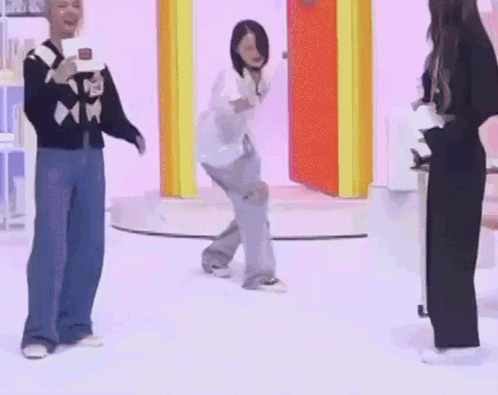A Group Of People Are Dancing On A Stage While A Man Holds A Microphone . GIF