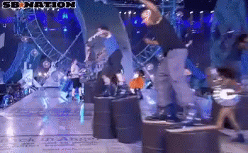 A Group Of People Are Dancing On A Stage With A Sign That Says Senation GIF