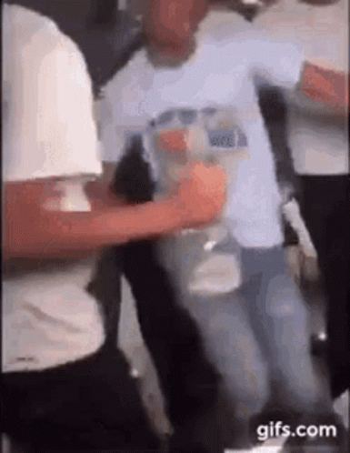 A Group Of People Are Dancing Together In A Room While A Man Is Holding A Bottle Of Water . GIF