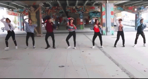 A Group Of People Are Dancing Under A Bridge In Front Of A Graffiti Wall . GIF