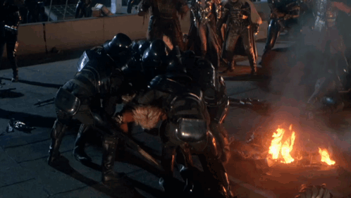 A Group Of People Are Fighting A Man In A Costume GIF