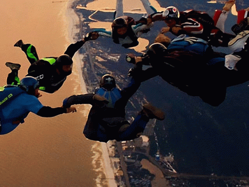 A Group Of People Are Flying Through The Air And One Of Them Is Wearing A Blue Shirt That Says ' Sd ' On It GIF