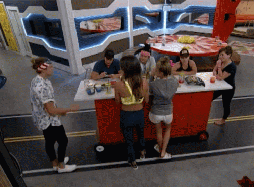 A Group Of People Are Gathered Around A Red Bar GIF