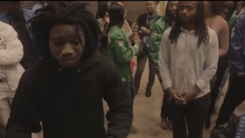 A Group Of People Are Gathered Around A Young Man In A Black Hoodie GIF