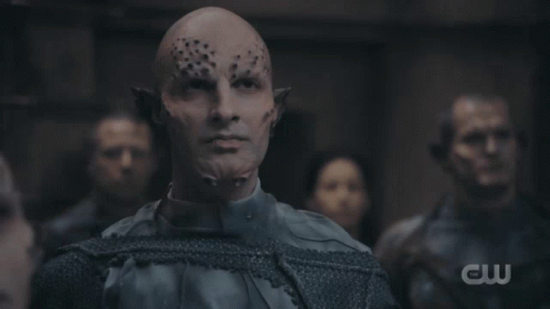 A Group Of People Are Gathered In A Dark Room With A Cw Logo In The Background GIF