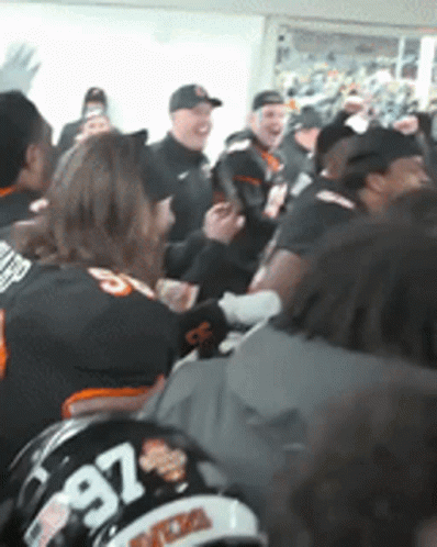 a group of people are gathered in a room and one of them has a helmet with the number 97 on it