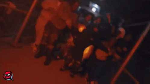 A Group Of People Are Gathered In A Room And One Of Them Is Wearing A Hooded Sweatshirt . GIF
