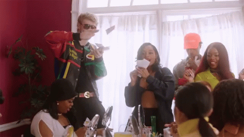 A Group Of People Are Gathered In A Room And One Of Them Is Wearing A Jacket That Says Supreme On It GIF