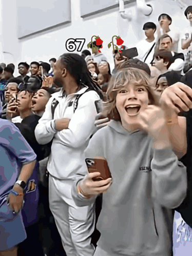 A Group Of People Are Gathered In A Room With The Number 67 Above Them GIF