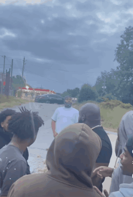 A Group Of People Are Gathered On The Side Of A Road GIF