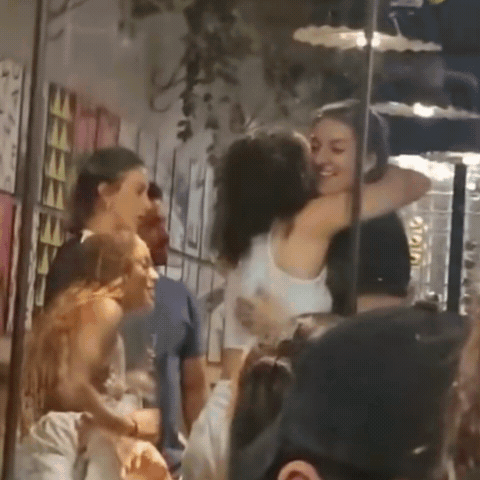 A Group Of People Are Hugging Each Other In A Store . GIF