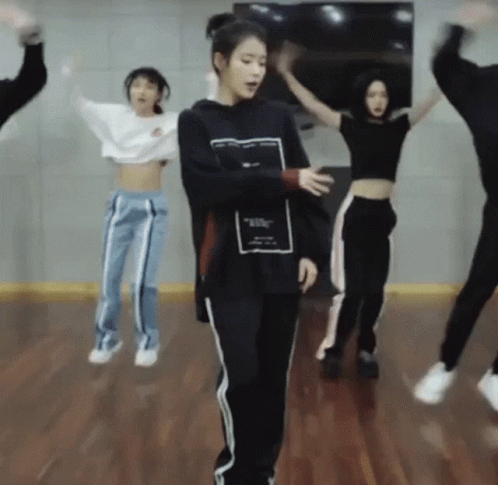 A Group Of People Are Jumping In The Air While Dancing In A Dance Studio . GIF