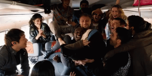 A Group Of People Are Laughing And Having Fun In A Room GIF