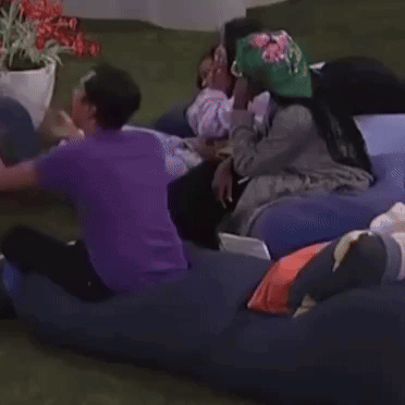 A Group Of People Are Laying On A Couch With One Wearing A Hat That Says ' A ' On It GIF