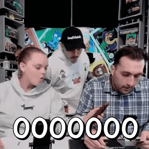 A Group Of People Are Looking At Their Phones And One Of Them Is Wearing A Hat That Says Veerfriends GIF