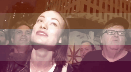 A Group Of People Are Looking Up At Something In Front Of A Sign That Says Pan GIF