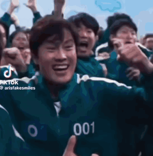 a group of people are playing a game called squid game and one of them is wearing a number 001 jacket .
