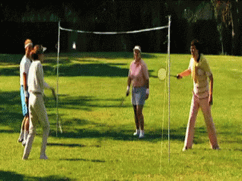 A Group Of People Are Playing A Game Of Badminton On A Lush Green Field GIF