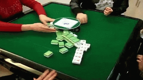 A Group Of People Are Playing A Game Of Mahjong At A Table . GIF