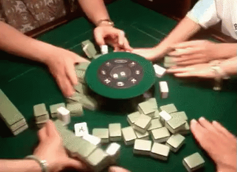 A Group Of People Are Playing A Game Of Mahjong . GIF
