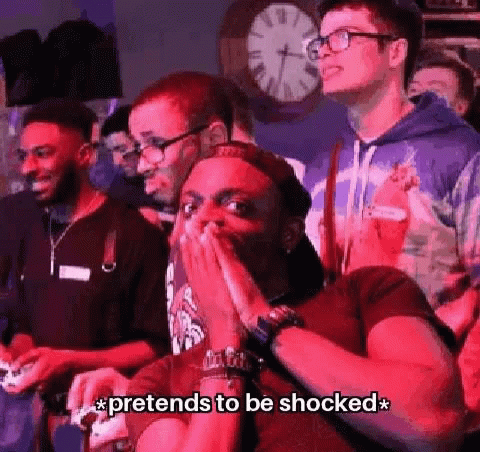 A Group Of People Are Playing A Video Game And One Of Them Is Covering His Mouth . GIF